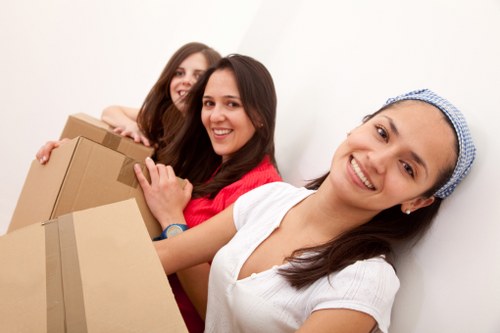 Movers carrying furniture through a Bermondsey flat hallway